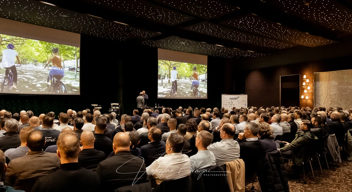 a man standing in front of a crowd for a corporate event